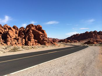 Country road and rock formations against blue sky