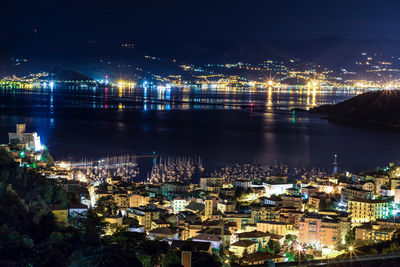 High angle view of illuminated buildings by river at night