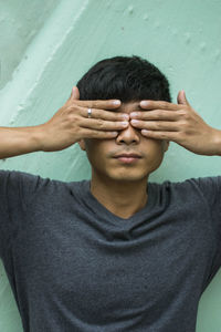 Portrait of man covering face with hands