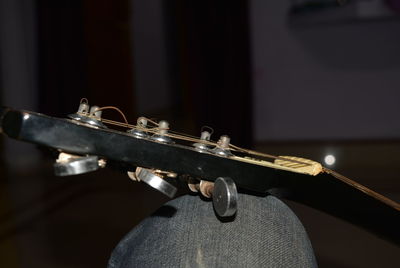 Close-up of guitar on leg of person