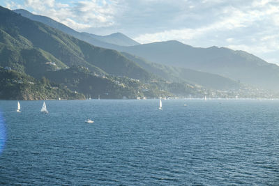 Scenic view of sea and mountains against sky