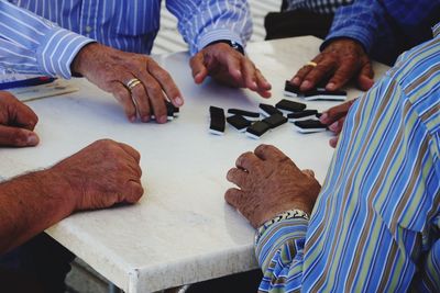 Men playing dominoes on table