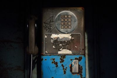 Close-up of rusty sign on old door