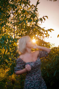 Rear view of woman standing against trees