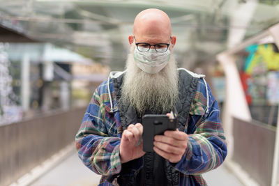 Portrait of man photographing with mobile phone