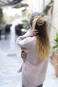 Teenage girl wearing sweater standing in city