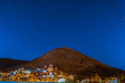 Panoramic view of illuminated buildings against clear blue sky at night