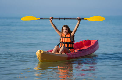 Young woman kayaking in sea