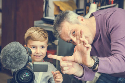 Boy with grandfather using television camera