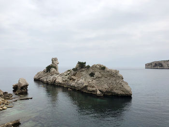 Rocks in sea against sky