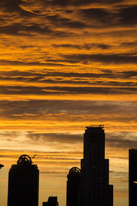 Silhouette buildings against sky during sunset