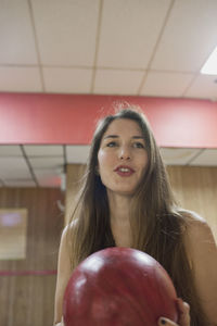 A young woman bowling.