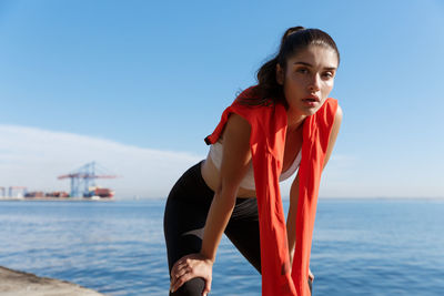 Portrait of young woman against sea