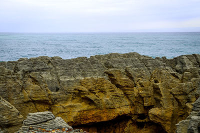 Close-up of rock formation in sea against sky