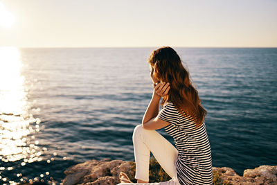 Woman looking at sea against sky