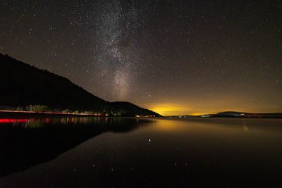 Scenic view of lake against sky at night