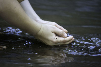 Cropped hands of woman in lake