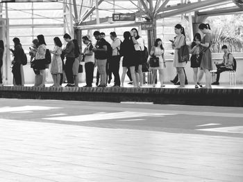 Group of people walking on sidewalk in city