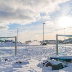 Scenic view of football field by the ocean covered in snow