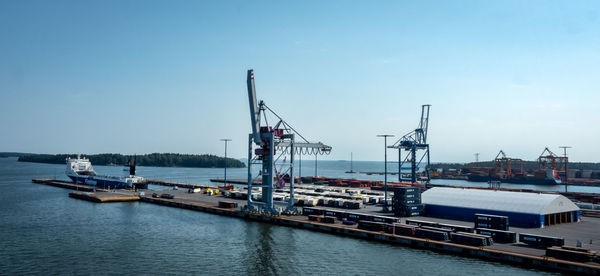 Sailboats moored at harbor against sky