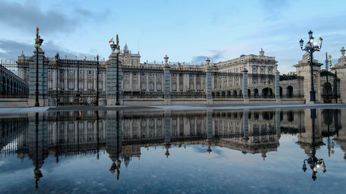 Royal palace in madrid reflecting in water after a rainy day, spain. reflection of royal palace