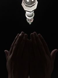 Low angle view of people hand against black background