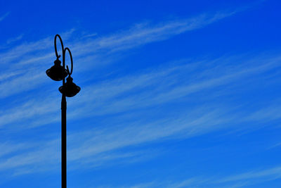 Low angle view of street light against blue sky