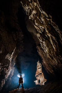 Mid adult man climbing standing in cave