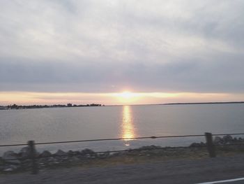 Scenic view of sea against cloudy sky at sunset