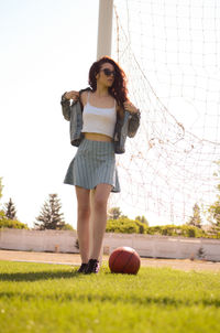 Portrait of young woman standing on field