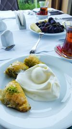 Close-up of fresh baklava served with cream in plate on table