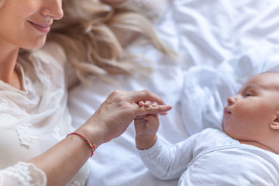 Woman holding hand of baby at home