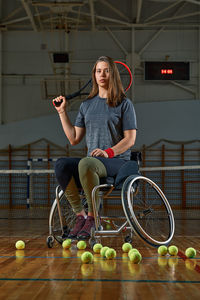 Portrait of young woman sitting on tennis