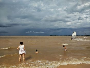 People on beach against sky