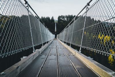 View of footbridge through chainlink fence