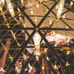 Low angle view of illuminated light bulbs hanging from ceiling