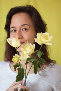 Portrait of woman holding yellow flowers