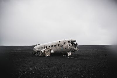 Abandoned airplane on runway against sky