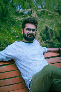 Portrait of young man wearing sunglasses sitting outdoors