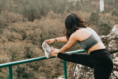 Young woman stretching on railing