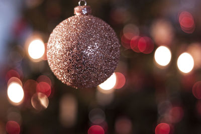 Close-up of shiny bauble hanging on christmas tree