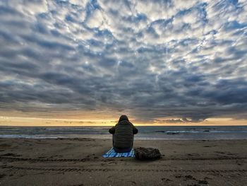 Rear view of man sitting on beach