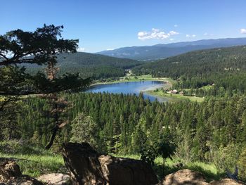 Scenic view of lake and mountains against blue sky