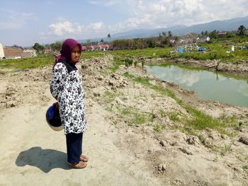 Full length of woman standing on land against sky