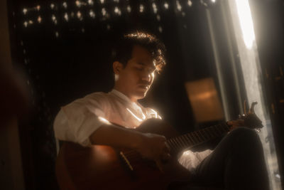 Man playing guitar at home