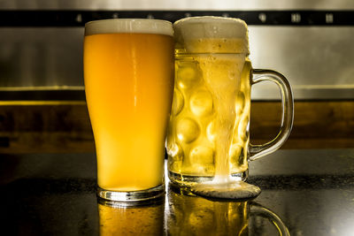 Close-up of beer glasses on table at bar