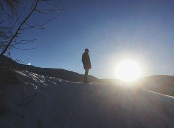 Low angle view of woman standing against sky during sunset