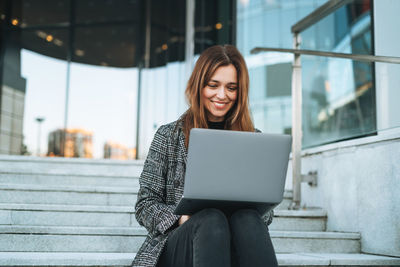 Portrait of young woman using laptop at home