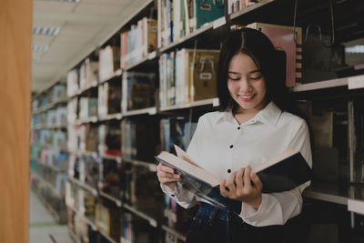 Portrait of young woman standing in library