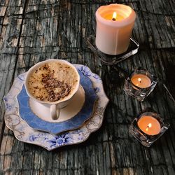 High angle view of coffee cup and candles on table